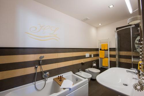 a bathroom with a tub and a sink and a toilet at Hotel Ligure in Alassio