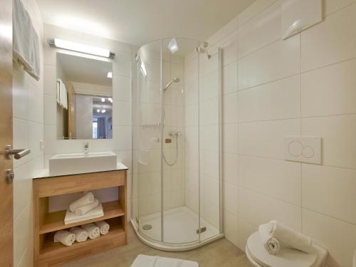 een badkamer met douche, toilet en wastafel bij Jägerhaus Apartment near ski area in Hopfgarten im Brixental