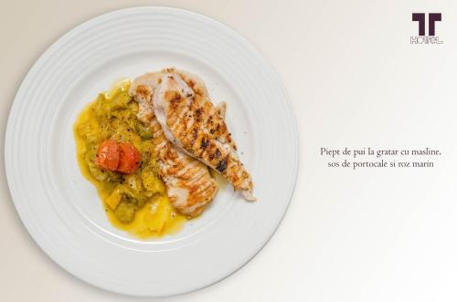 a plate of food with a piece of meat on it at Hotel Tolea in Târgovişte