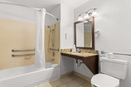 a bathroom with a toilet and a sink and a tub at Quality Inn & Suites Denver International Airport in Denver