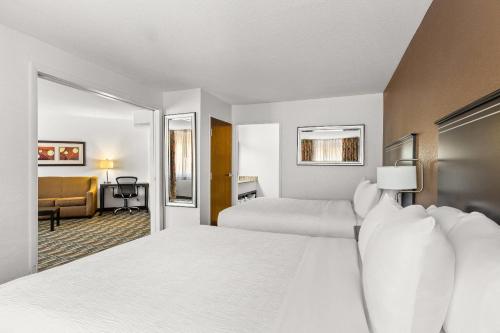 a hotel room with two beds and a couch at Quality Inn & Suites Denver International Airport in Denver