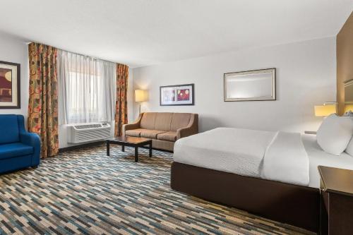 a hotel room with a bed and a couch at Quality Inn & Suites Denver International Airport in Denver
