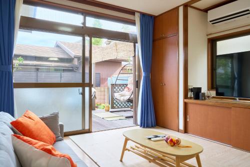 a living room with a table and a large window at Family Garden House Tokyo Machida in Machida