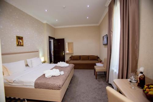 Habitación de hotel con cama y sofá en Rustaveli Palace, en Tiflis