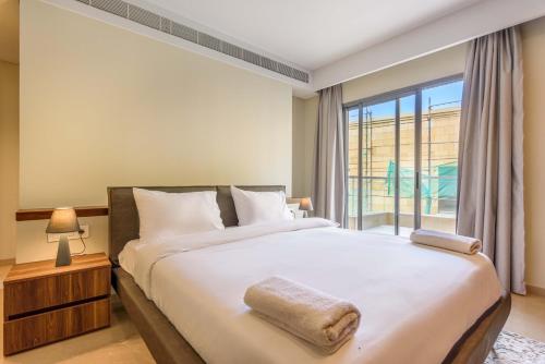 a bedroom with a large bed with a large window at Solidere Lavish Apartments in Downtown Beirut in Beirut