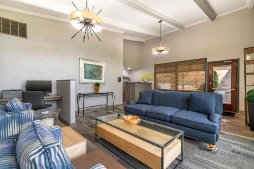 a living room with a blue couch and a table at The Inn at Gran View Ogdensburg, an Ascend Collection Hotel in Ogdensburg