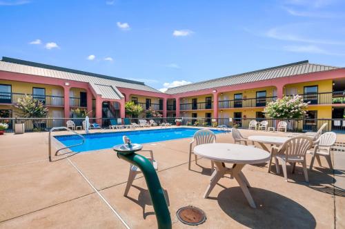 a hotel patio with tables and chairs and a pool at Quality Inn Fredericksburg-Central Park Area in Fredericksburg