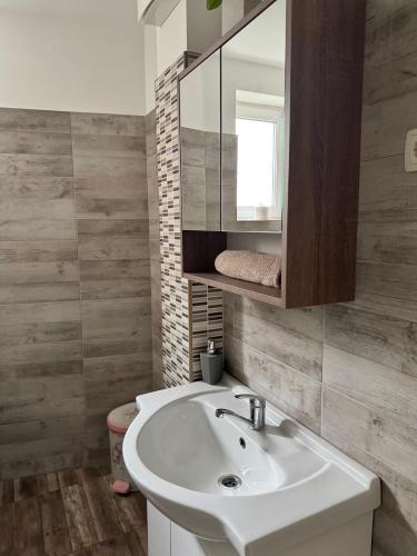 a bathroom with a white sink and a mirror at Platinum Guesthouse in Szeged