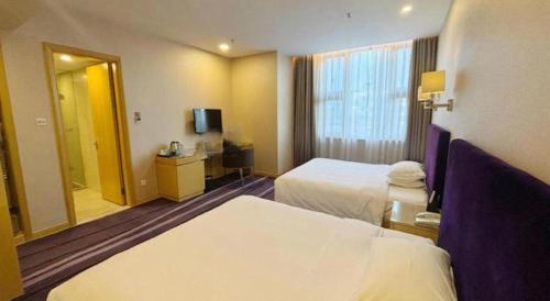 a hotel room with two beds and a mirror at The Bauhinia in Shenzhen