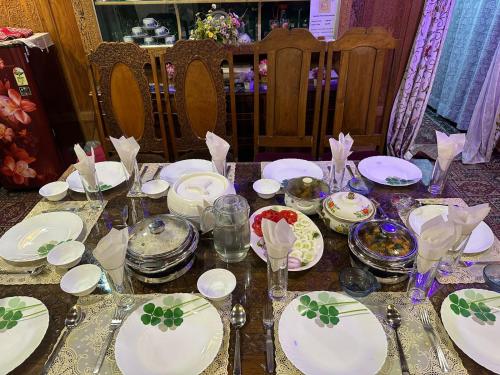 a table with white plates and glasses on it at Luxury freedom group of houseboats in Srinagar