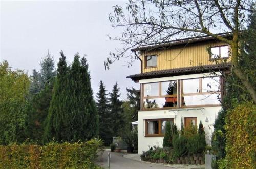 ein weißes Haus mit gelbem Dach in der Unterkunft Zum Rebberg Ferienwohnungen in Freiburg im Breisgau