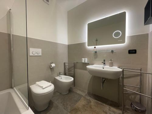 Un baño con inodoro, lavabo y espejo. en HFA Morosini by the Sea parcheggio incluso, en Génova