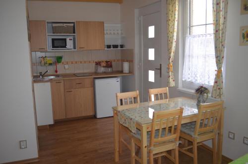 a kitchen with a table and chairs and a kitchen with a sink at Ubytování u Muzea hraček in Lednice