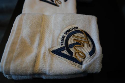 a white towel with a logo on it at The Central View Boutique Hotel in Vlorë
