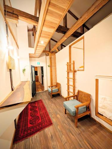 a living room with a chair and a red rug at Kaido Nomad CoLiving in Yuzawa