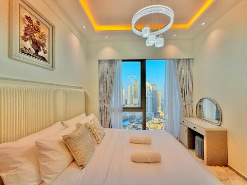 a bedroom with a white bed and a large window at Grande Downtown Dubai Luxury 2BR Apt with Burj Khalifa & Dubai Fountain Views in Dubai