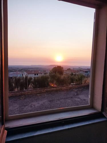 a view of the sunset through a window at PM 135 Corso Umberto Guest House in Cuglieri