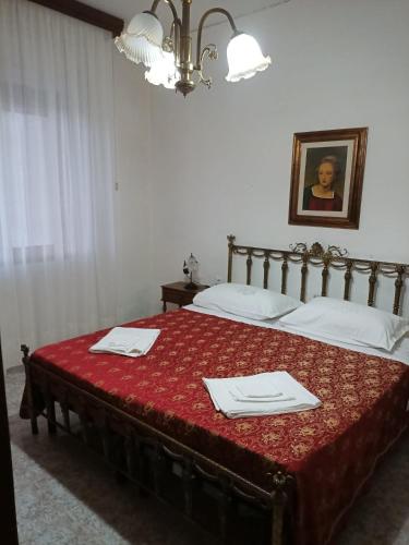 a bedroom with two beds with a red bedspread at PM 135 Corso Umberto Guest House in Cuglieri