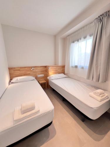 a bedroom with two beds and a window at Camping Joncar Mar in Roses