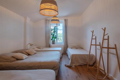 a room with three beds and a chandelier at La roche étoilée - Jacuzzi in Vienne