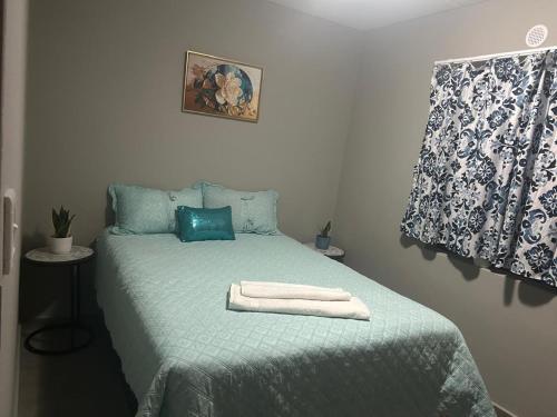 a bedroom with a green bed with towels on it at Gwendolen in Pretoria