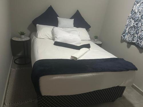 a bed with a book sitting on top of it at Gwendolen in Pretoria