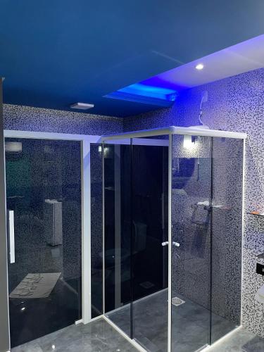 a bathroom with a glass shower with a blue ceiling at Agha Motel in Canela