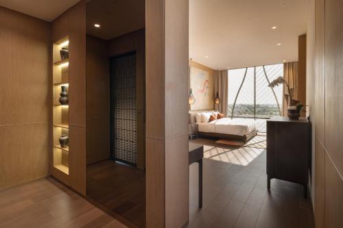 a bedroom with a bed and a living room at SOMA HOTEL Riverside in Phnom Penh