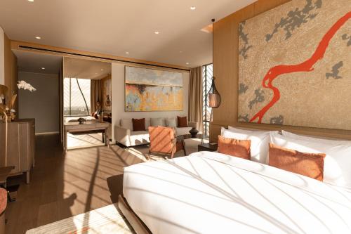 a bedroom with a bed and a living room at SOMA HOTEL Riverside in Phnom Penh