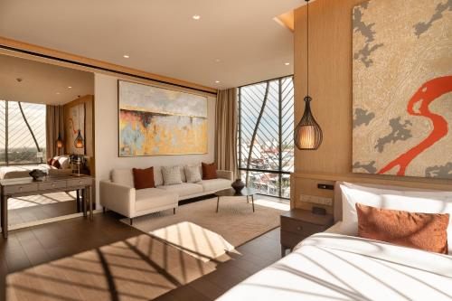 a bedroom with a bed and a living room at SOMA HOTEL Riverside in Phnom Penh