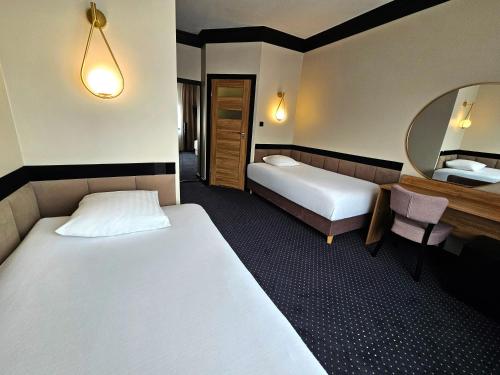 a hotel room with two beds and a mirror at Willa Pirs in Warsaw