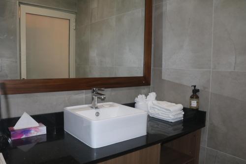 a bathroom with a sink and a mirror and towels at Nawi Island Marina Accommodation in Savusavu