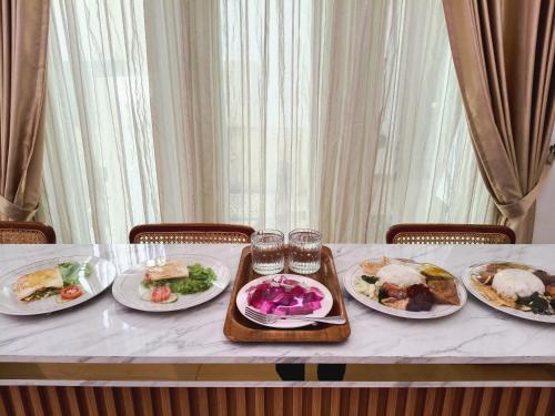 a table with four plates of food on it at Omah Ulfah Homestay in Banyuwangi