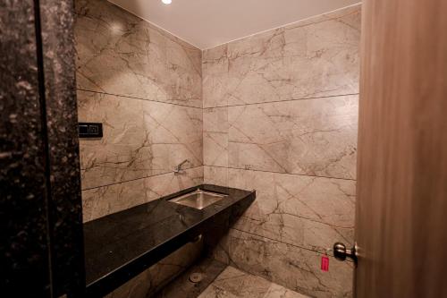 a bathroom with a stone shower with a sink at Hotel Gold Palace Inn in Surat