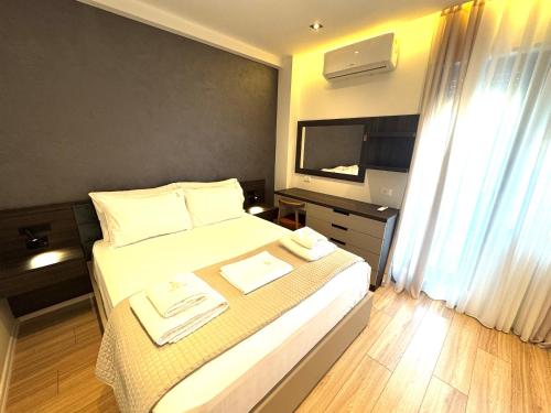 ein Hotelzimmer mit einem Bett und einem Fernseher in der Unterkunft Luxurious & Spacious Old Bazaar Apartment in Tirana
