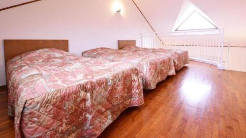 two beds in a room with a room with a window at Petit Hotel Key West Club in Naha
