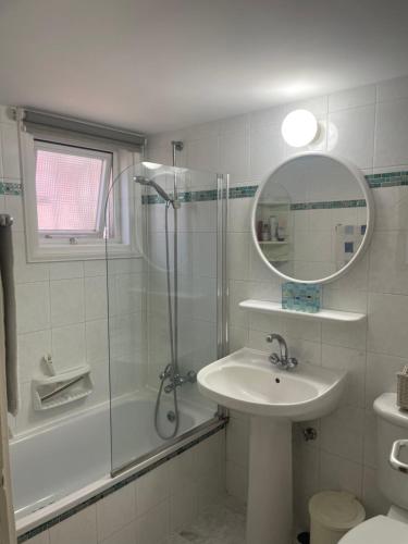 a bathroom with a shower and a sink and a mirror at Pelagos Hill Apartment in Paphos