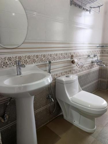 a bathroom with a sink and a toilet and a mirror at Mawdong Homestay in Shillong