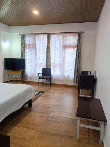 a bedroom with a bed and a table and chairs at Mawdong Homestay in Shillong