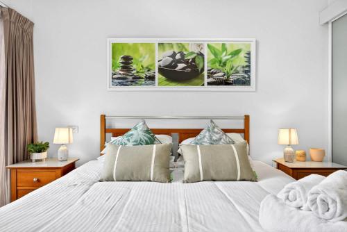 a bedroom with a large white bed with pillows at Cloud Nine City Centre 1BDR in Perth