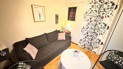 a living room with a black couch and a table at Cozy Family Villa for aurora lovers in Byske