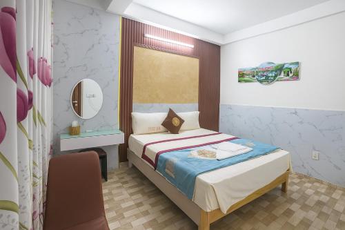 Un pequeño dormitorio con una cama y una silla. en Nhà Nghỉ Thu Hằng 1, en Hà Ðông