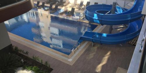 a blue water slide in a swimming pool at Cozy apartment for family vacation in Besthome 20 in Alanya