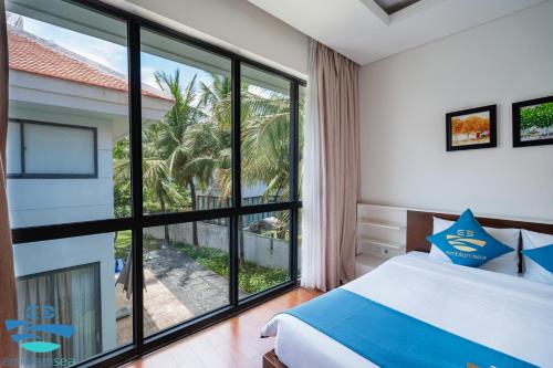 a bedroom with a bed and a large window at Esea43 private pool villas in Danang