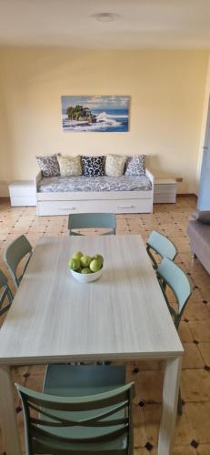 a table with a bowl of fruit on it in a room at Holiday Apartment Piazza Bacio Sublime in Fiumefreddo di Sicilia