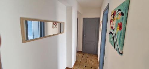 a hallway with a mirror on a wall next to a door at Holiday Apartment Piazza Bacio Sublime in Fiumefreddo di Sicilia