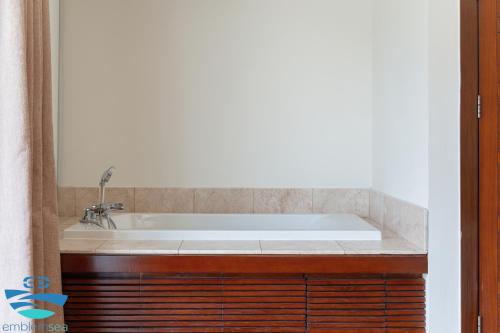 a bath tub in a bathroom with a mirror at Esea43 private pool villas in Danang