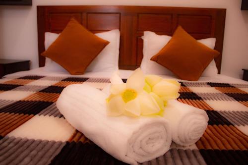a towel on a bed with a flower on it at Cieloblu In Hotel Matara in Palatuwa