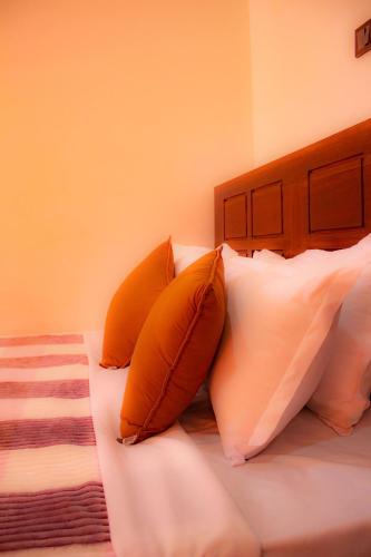 a bed with two orange pillows on it at Cieloblu In Hotel Matara in Palatuwa