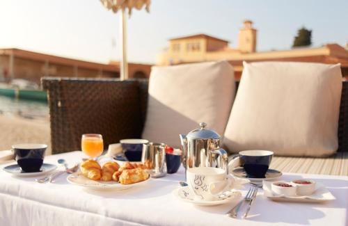 a table with a white table cloth with food on it at Welcome Hotel in Villefranche-sur-Mer